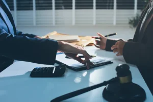 Two business people at a table with a calculator and pen